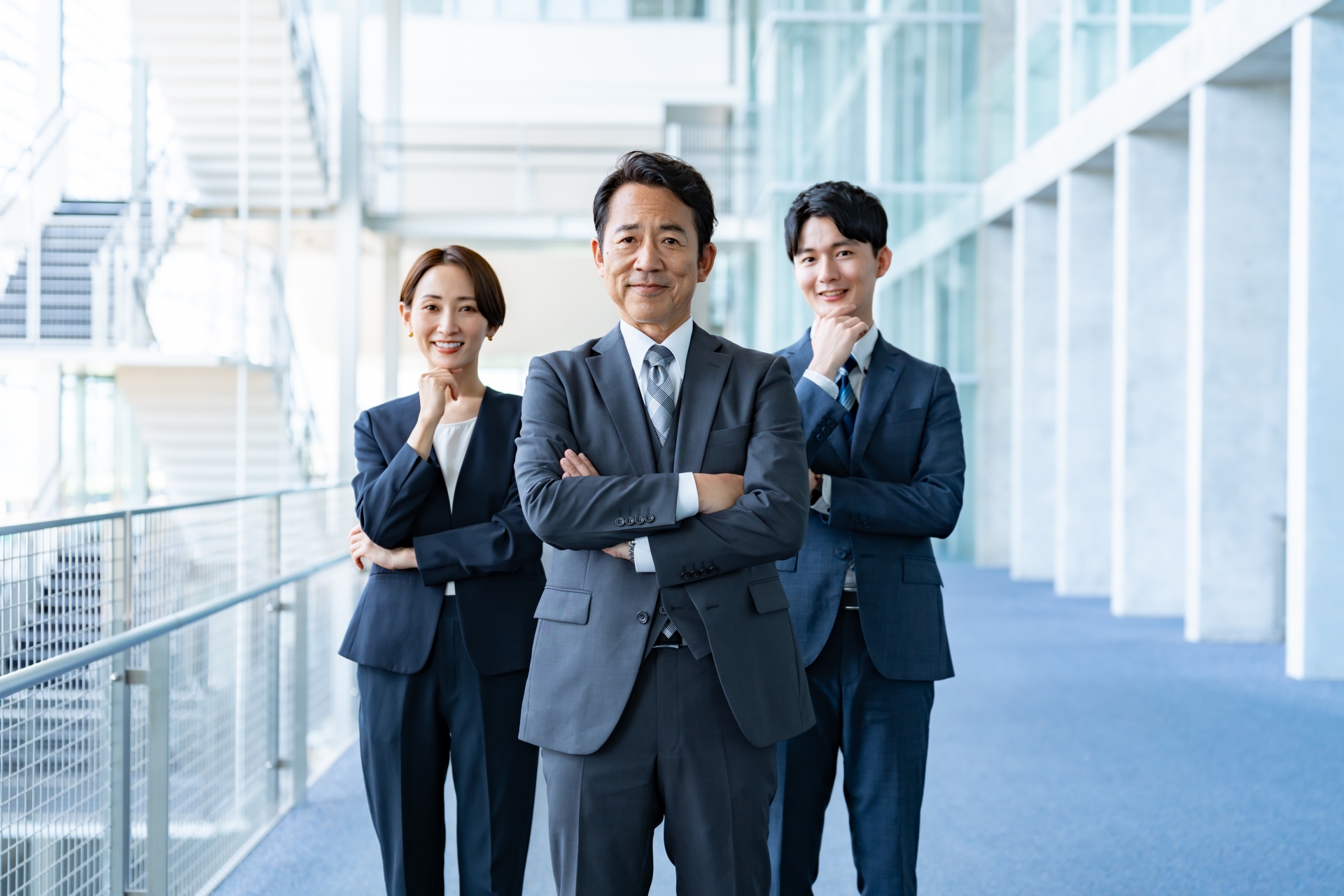 オフィスに並ぶ3人のビジネスパーソン