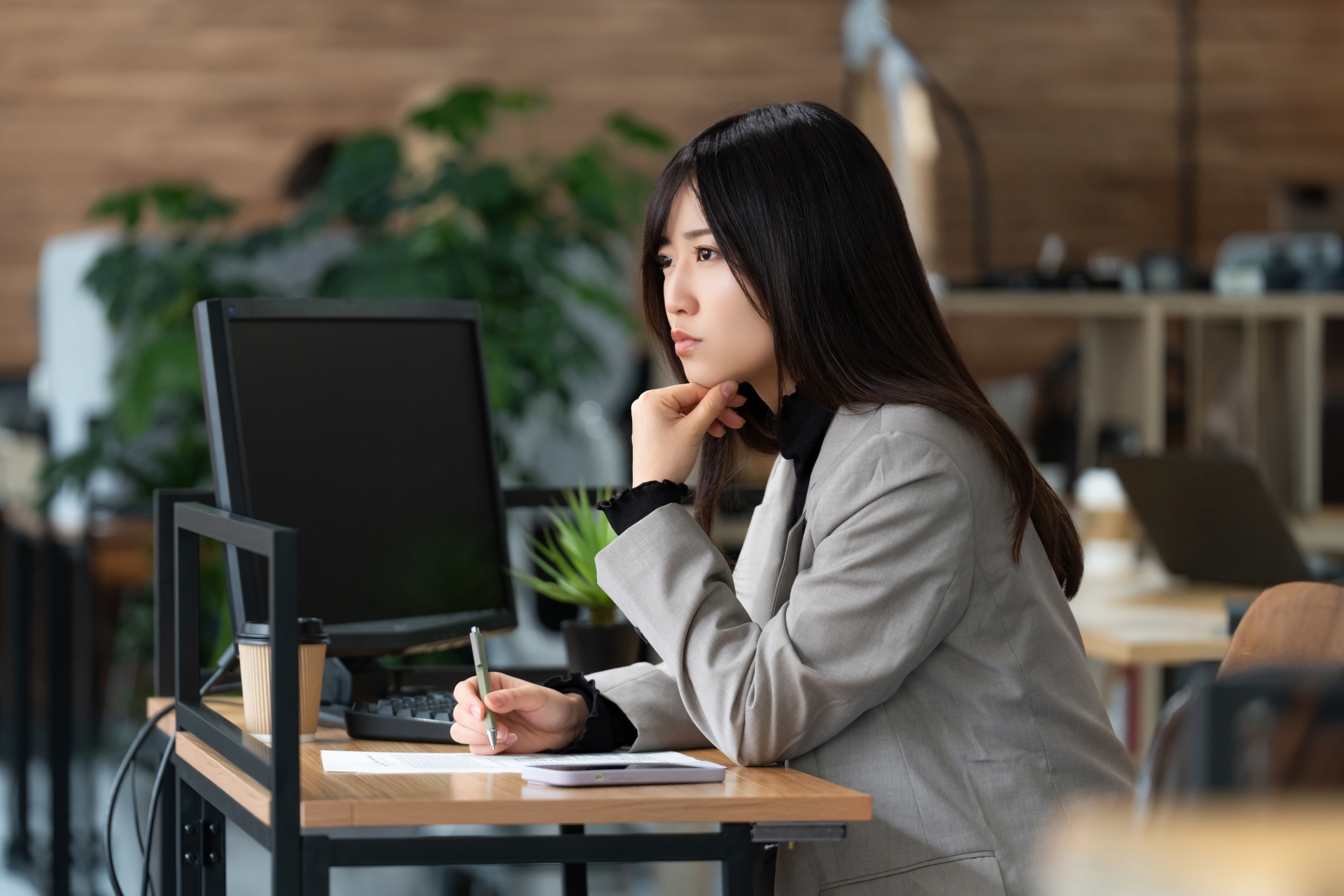 考え込むスーツ姿の女性