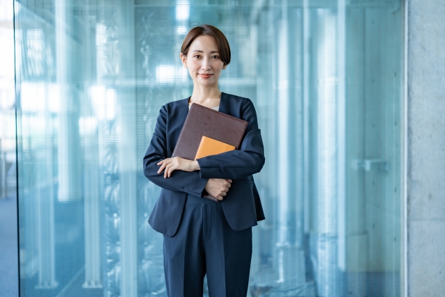 ファイルを抱えたスーツの女性