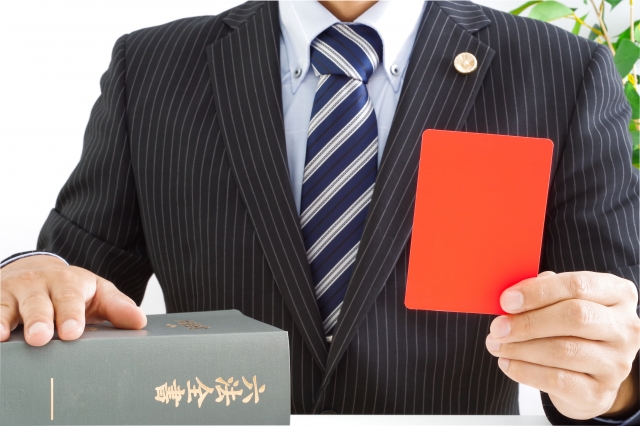 レッドカードを見せる弁護士