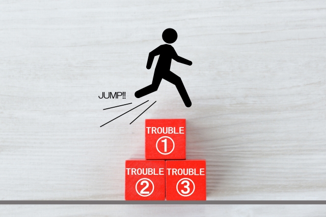 「TROUBLE」と書かれた箱の上をジャンプする人物のアイコン