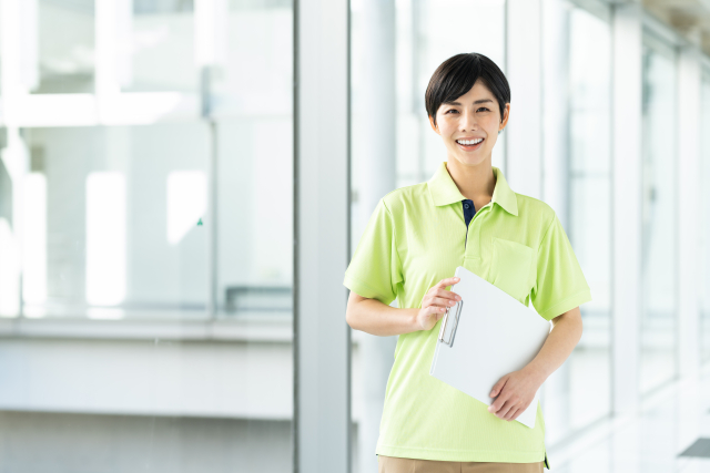 バインダーを持った女性介護スタッフ