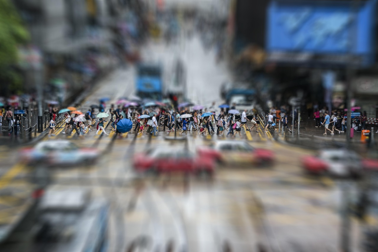 傘を刺して横断歩道を渡る群衆