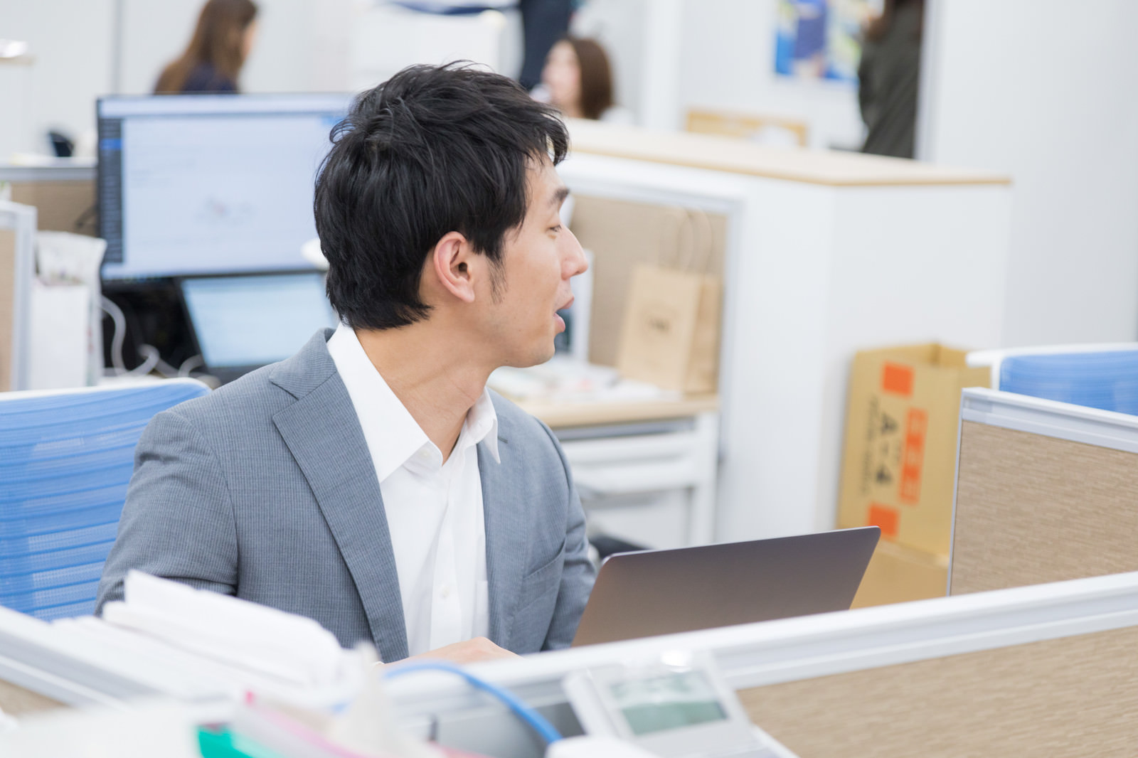 隣の席の人に話しかける男性
