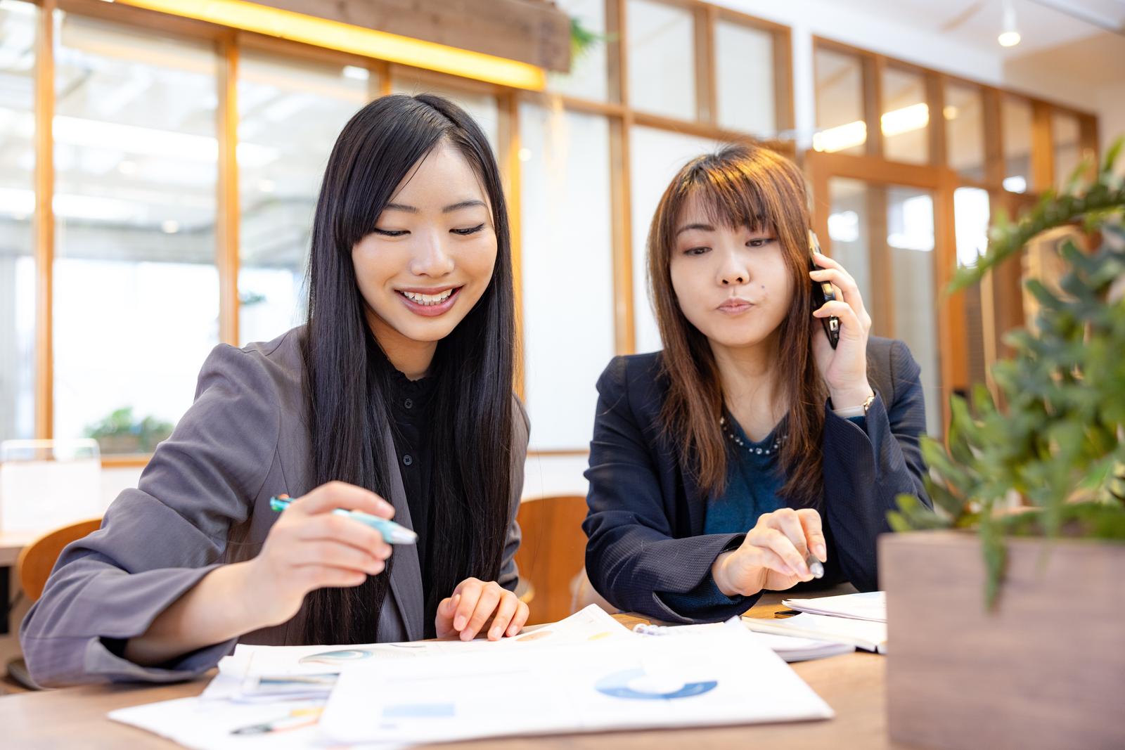 資料を見ながら話す女性会社員