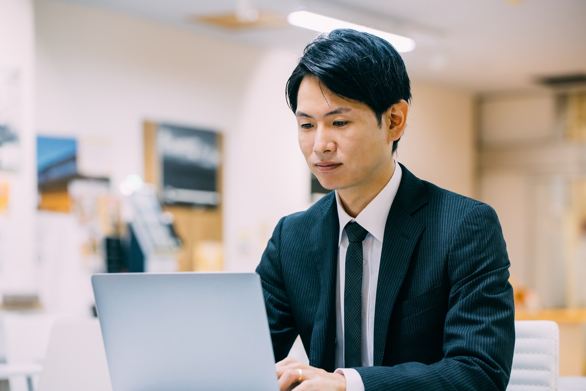 ノートパソコンを見ながら仕事をする男性