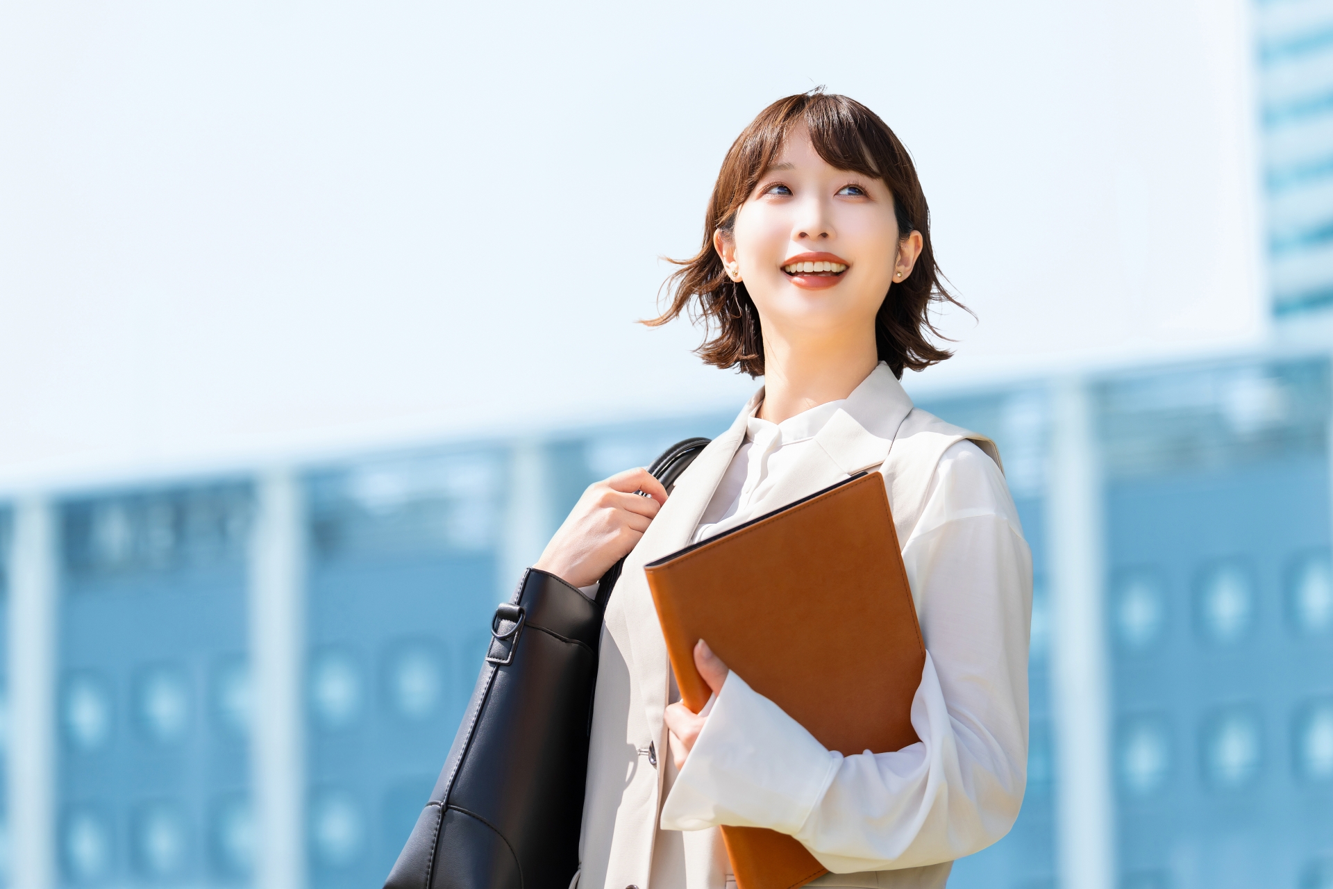 笑顔で外を歩く女性会社員