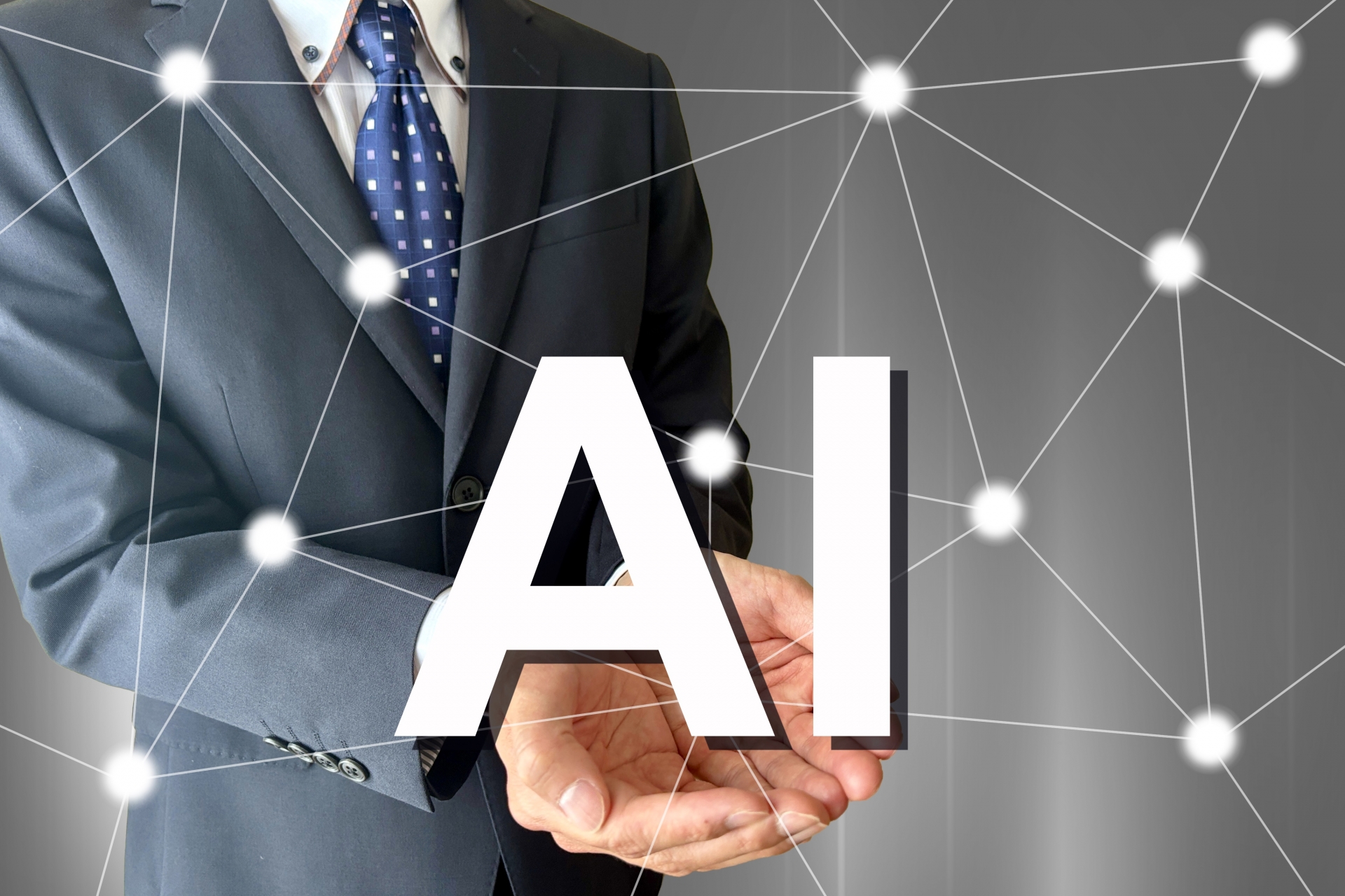 スーツ姿の男性と「AI」の文字